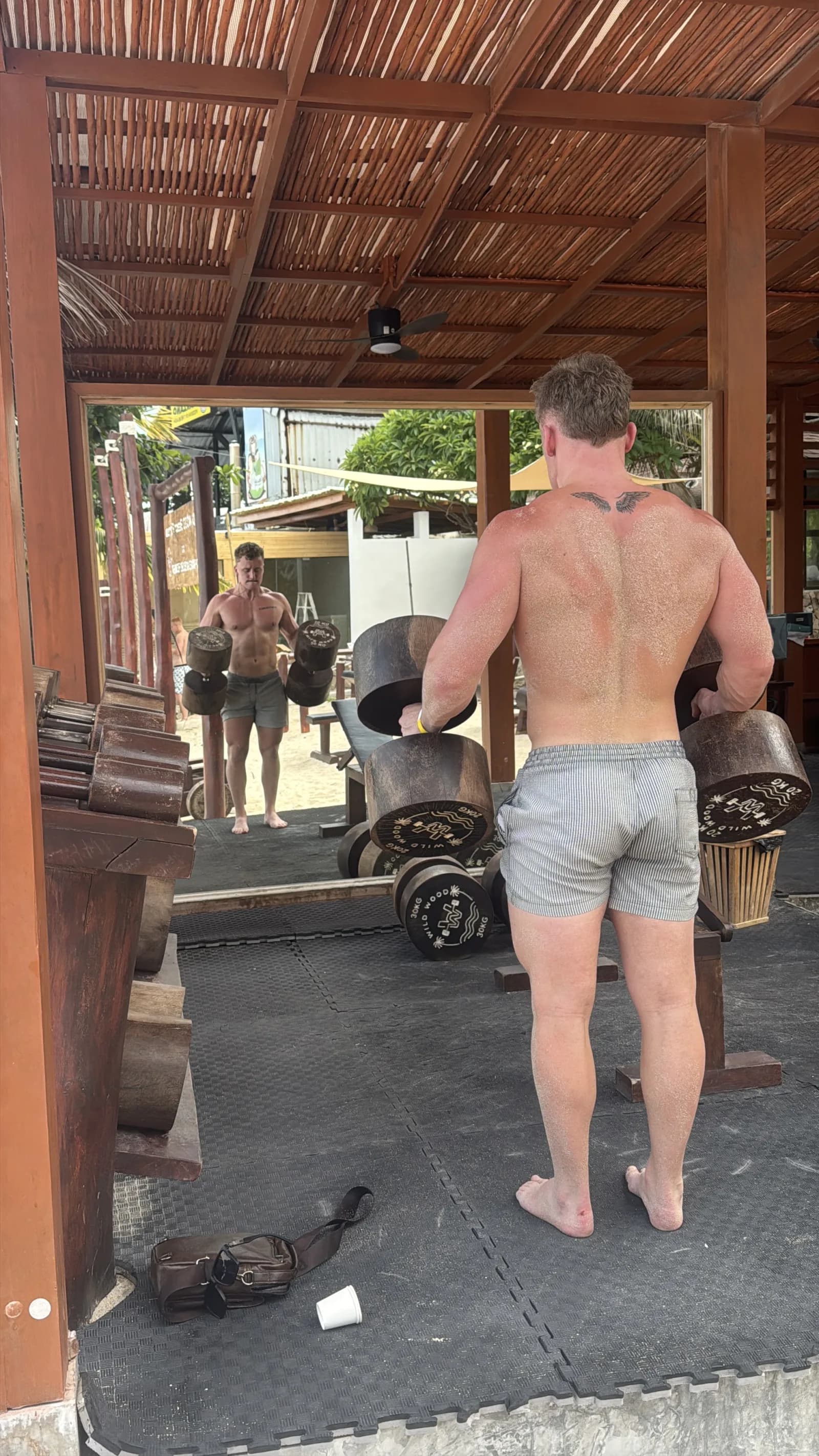 Training with wooden log dumbbells at Wild Wood Beach Fitness, Ko Samui